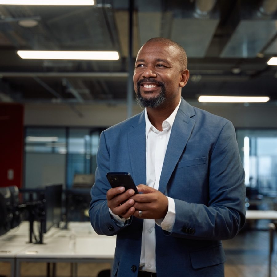 Mature,Black,Man,In,Businesswear,Smiling,While,Using,Mobile,Phone Mature,Black,Man,In,Businesswear,Smiling,While,Using,Mobile,Phone